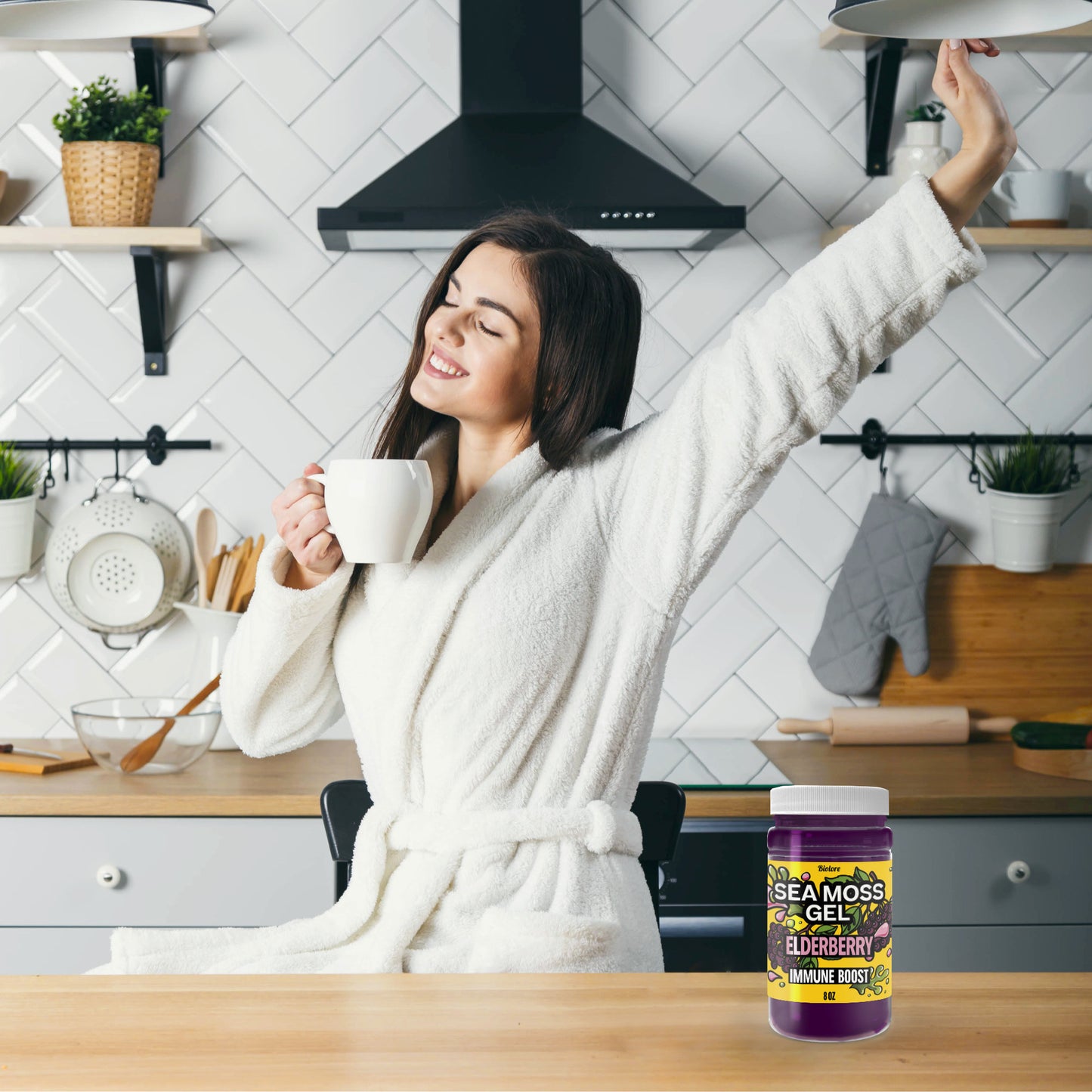 Woman enjoying a relaxed morning with coffee in the kitchen next to Biolore elderberry sea moss gel for daily wellness support.