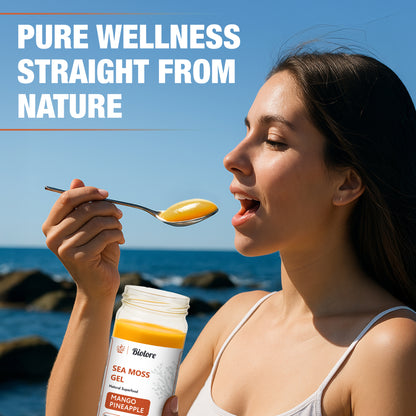 Woman eating Biolore mango pineapple sea moss gel by the ocean representing pure wellness.